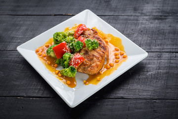 Tasty fried chicken meat with vegetables and lentils sauce on wooden background