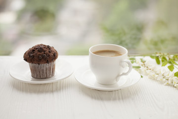 Top view on cup of coffee and chocolate cupcakes on white background. Cup of black coffee with chocolate muffins.
