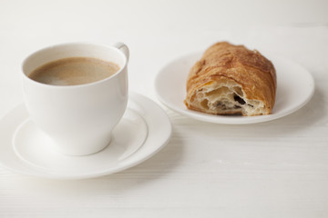 Coffee cup and fresh baked croissants on wooden background. Top View