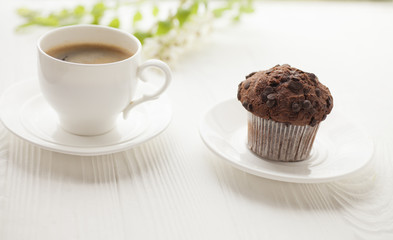 Top view on cup of coffee and chocolate cupcakes on white background. Cup of black coffee with chocolate muffins.