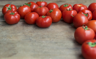 Fresh, red tomatoes on old wooden background