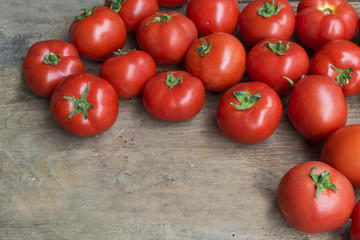 Fresh, red tomatoes on old wooden background
