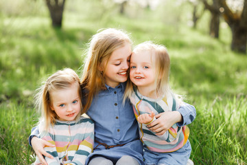 Fototapeta premium Three sister girls playing on the green park outdoor