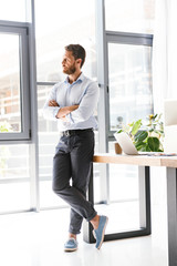 Fototapeta premium Handsome bearded man in office standing near table