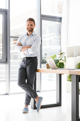 Cheerful happy bearded man in office