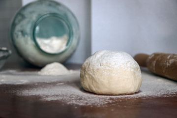 Raw dough on the table sprinkled with flour