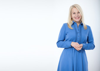 Friendly smiling middle aged woman in blue dress isolated