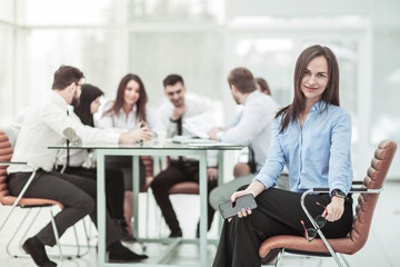 leading specialist at the woman sitting on office chair on the background of business team