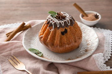 Plate with sweet cinnamon cake on table