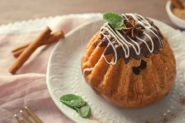 Plate with sweet cinnamon cake on table