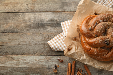 Sweet cinnamon bun on wooden table
