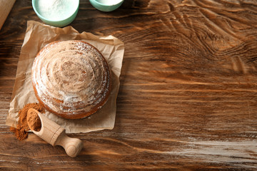 Sweet cinnamon bun on wooden table