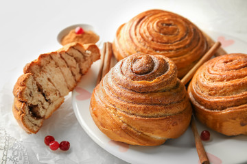 Plate with sweet cinnamon buns on table