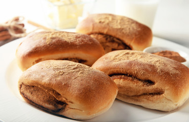 Sweet cinnamon buns on plate, closeup