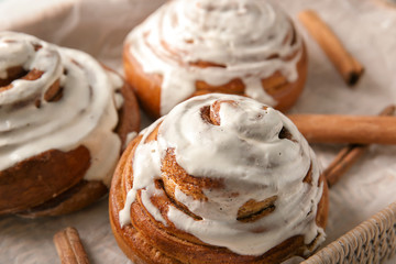 Wicker basket with glazed cinnamon buns, closeup