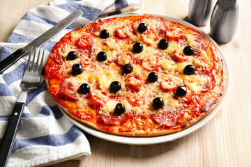 Plate with tasty Italian pizza on wooden table