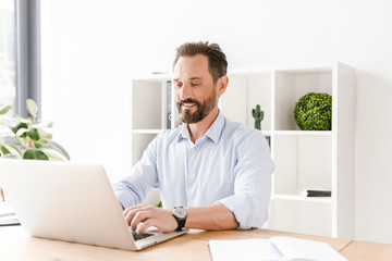 Fototapeta premium Smiling businessman working on laptop computer