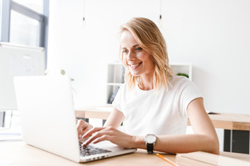 Smiling businesswoman working on laptop computer