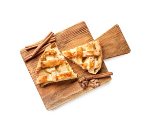 Wooden board with pieces of tasty homemade apple pie on white background