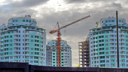 Fototapeta na wymiar Crane near buildings under construction. Construction site.