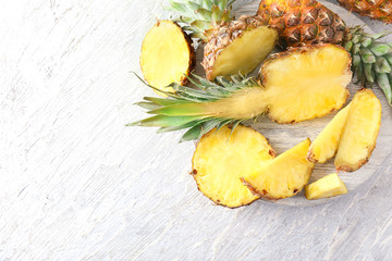 Stand with delicious pineapples on wooden background