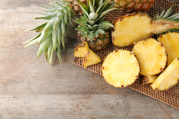 Delicious cut pineapples on wooden background