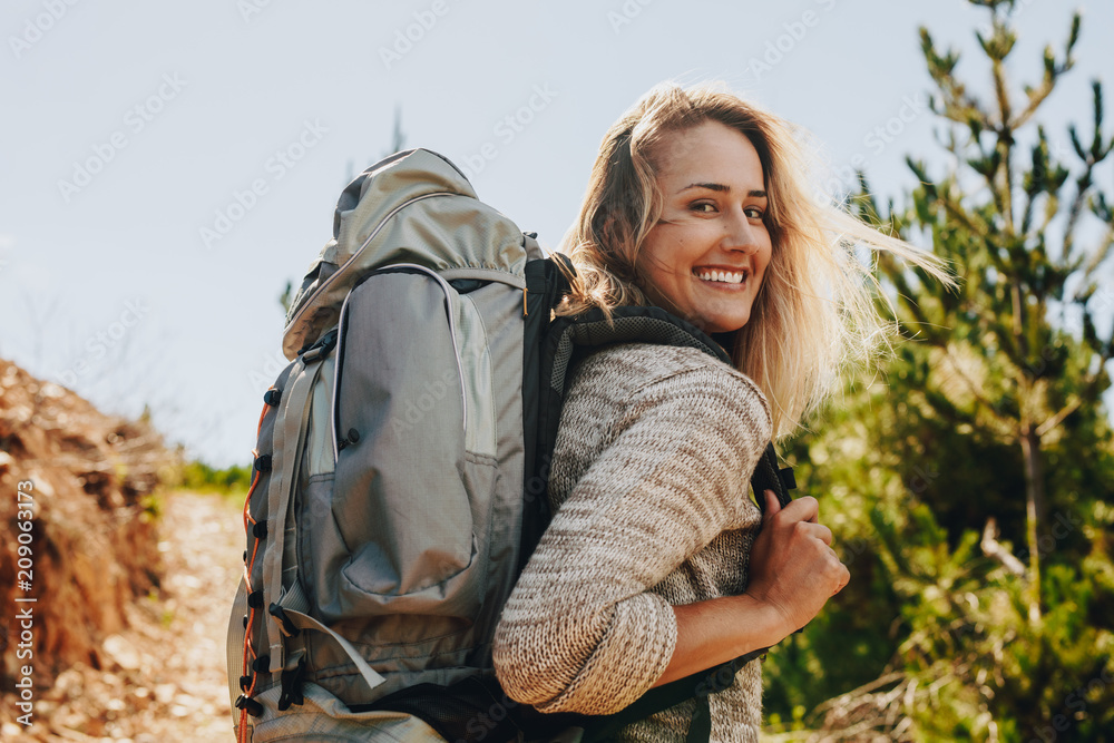 Wall mural woman with backpack hiking in nature