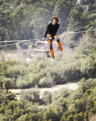 Highliner on a rope. Highline on a background of mountains. Extreme sport on the nature. Balancing on the sling. Equilibrium at altitude.