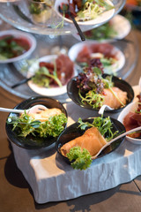 Tasty little snacks with meat and vegetables on served table at the restaurant