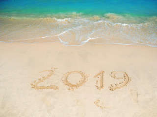Inscription on the sand, celebrate the new year in the tropics. New year holidays
