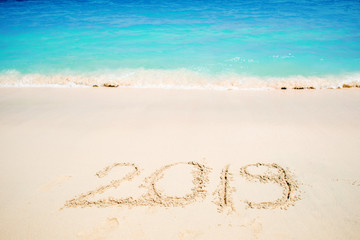 Inscription on the sand, celebrate the new year in the tropics. New year holidays