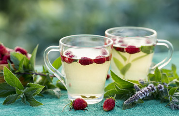 Two cups of hot tea with strawberry and mint. Outdoor.