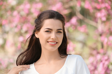 Naklejka premium Beautiful young woman in park on spring day