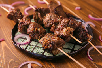 Plate with juicy meat on barbecue skewers