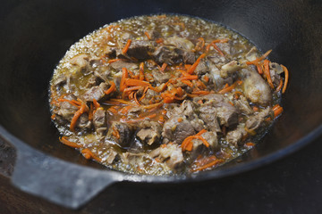preparation of pilaf in a cauldron on a fire