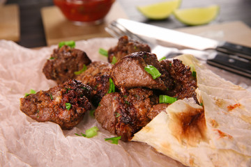 Pieces of shish-kebab on parchment, closeup