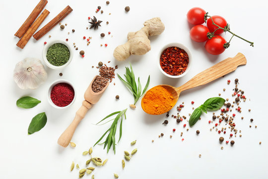 Fresh tomatoes and variety of spices on white background
