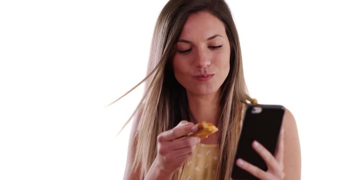 Close-up of girl taking selfie with phone while eating pizza on white background, Pretty woman taking selfie photo and eating slice of pizza on white copy space, 4k