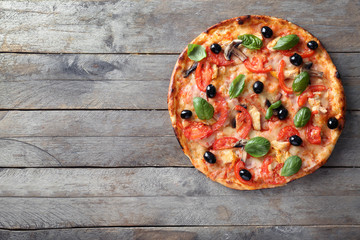 Tasty Italian pizza with olives on wooden background