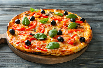 Board with tasty Italian pizza on wooden table