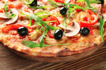 Board with tasty Italian pizza on wooden table, closeup