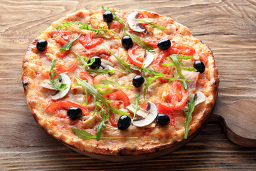 Board with tasty Italian pizza on wooden table