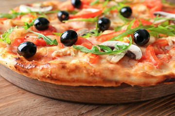 Board with tasty Italian pizza on wooden table, closeup