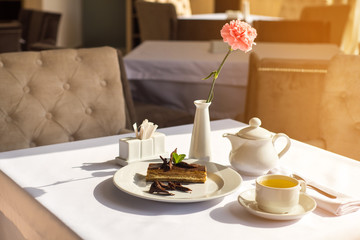 Sweet dessert and cup of tea on the table in the morning at the restaurant