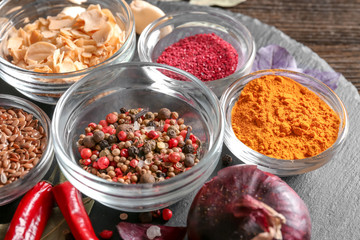 Bowls with various spices on slate plate, closeup