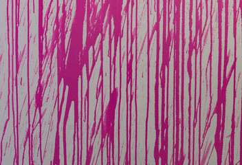 Pink paint splatter dripping on a wall