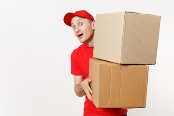 Delivery young man in red uniform isolated on white background. Male in cap, t-shirt, jeans working as courier or dealer holding empty cardboard boxes. Receiving package. Copy space for advertisement.