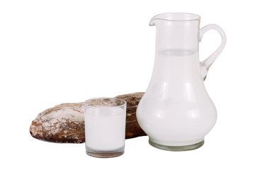 The jug of milk with glass and homemade bread