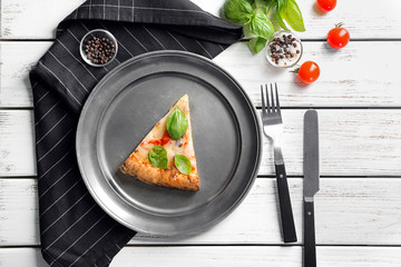 Composition with piece of delicious pizza Margherita on wooden background