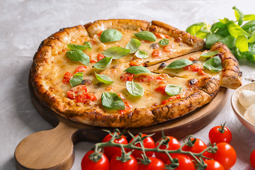 Board with delicious pizza Margherita on table